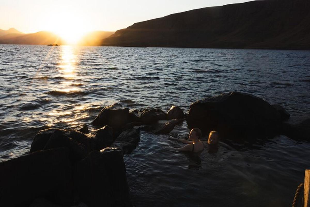 un gruppo di persone che nuotano nell'acqua al tramonto