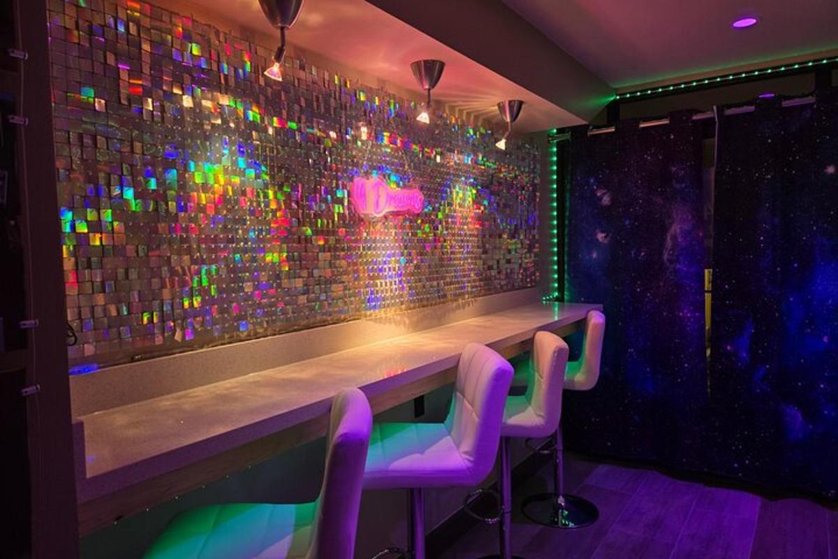 bar z vijoličnimi stoli in stena z barvitimi lučmi