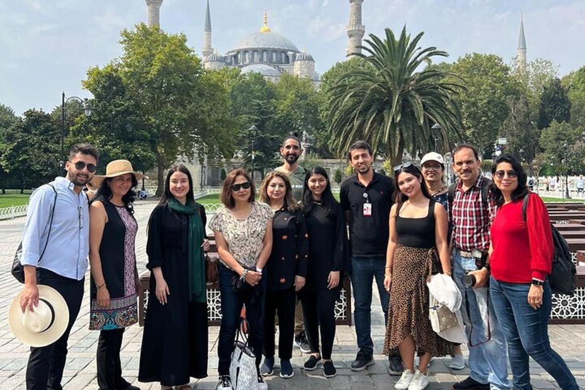 a group of people posing for a picture in front of a mosque