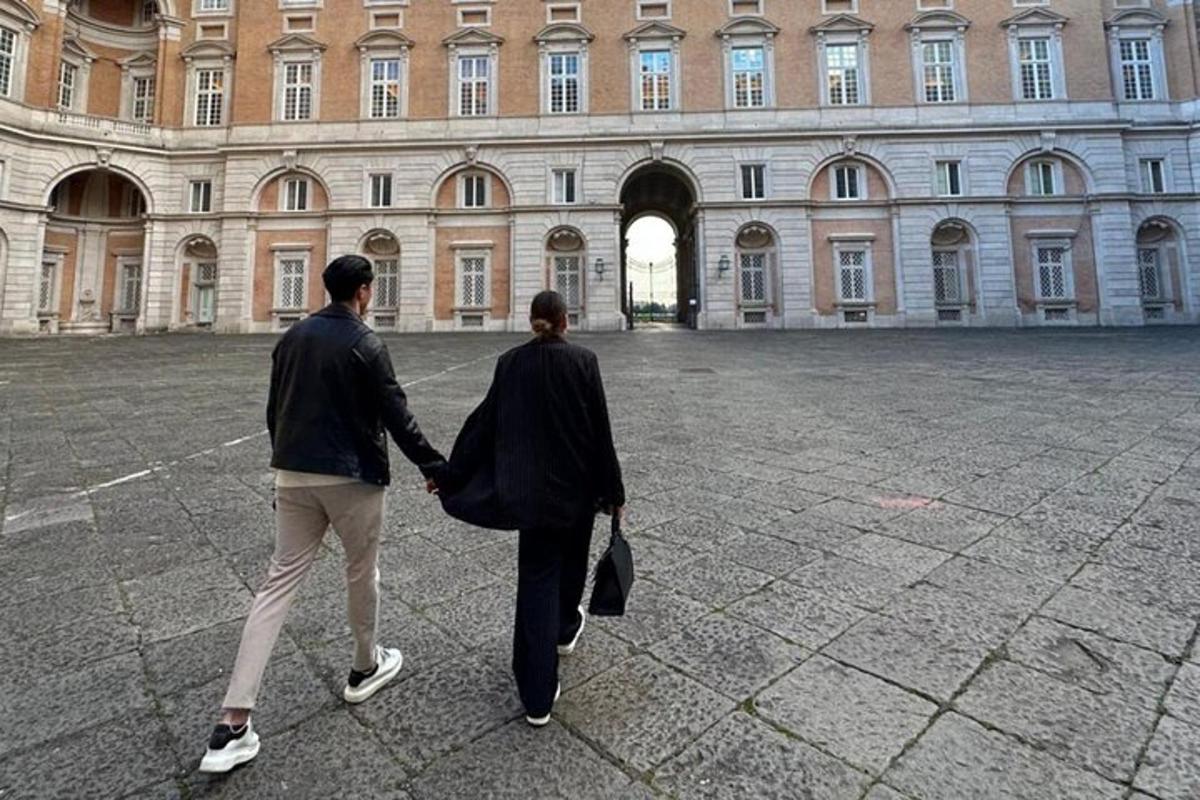 two people walking in front of a large building