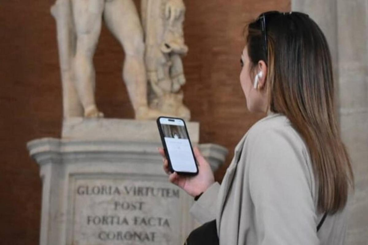 a woman holding a cell phone in front of a statue