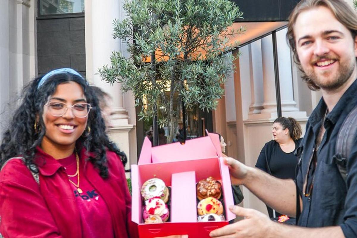 un uomo che porge una scatola di ciambelle a una donna