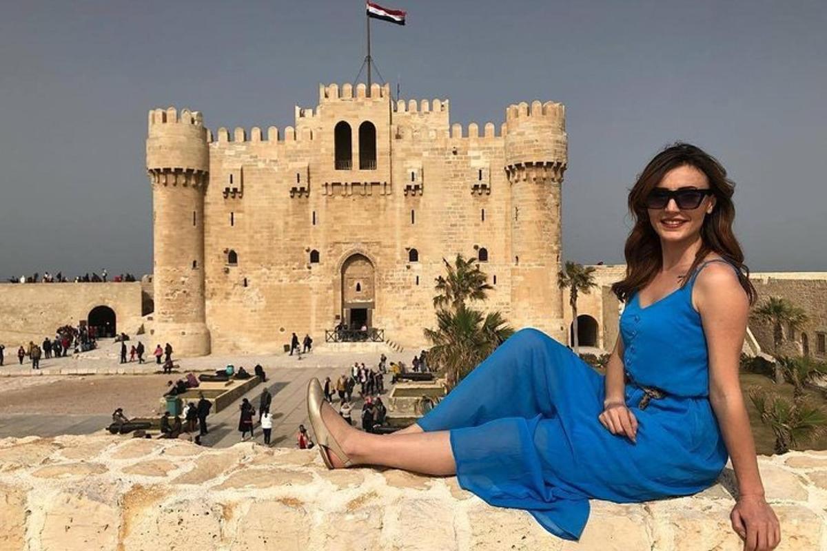 a woman sitting on a wall in front of a castle