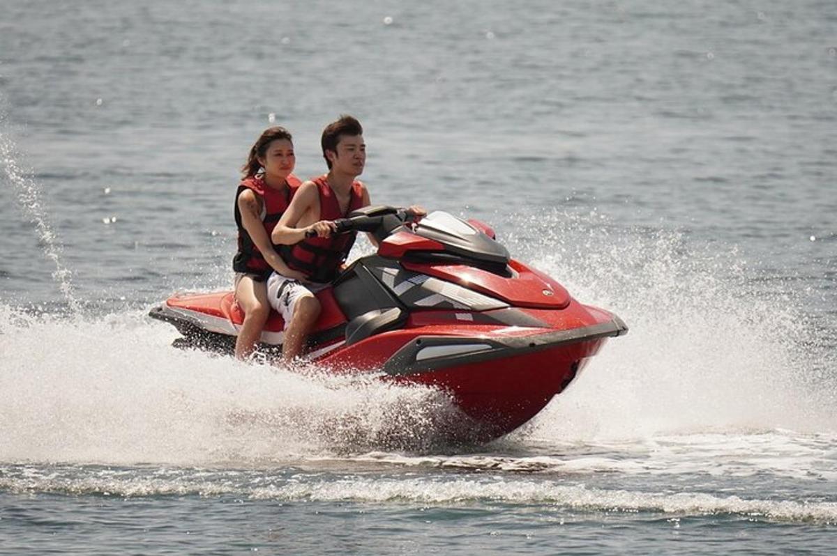 Un hombre y una mujer viajando en una moto acuática en el agua