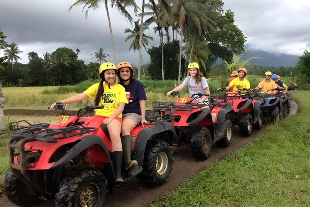 Un grupo de personas conduciendo vehículos todo terreno por un camino de tierra.