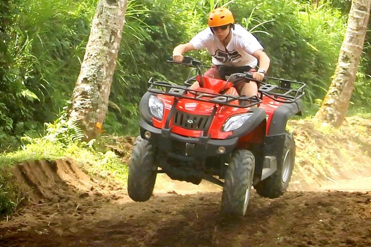 un uomo che guida un quad su una pista sterrata