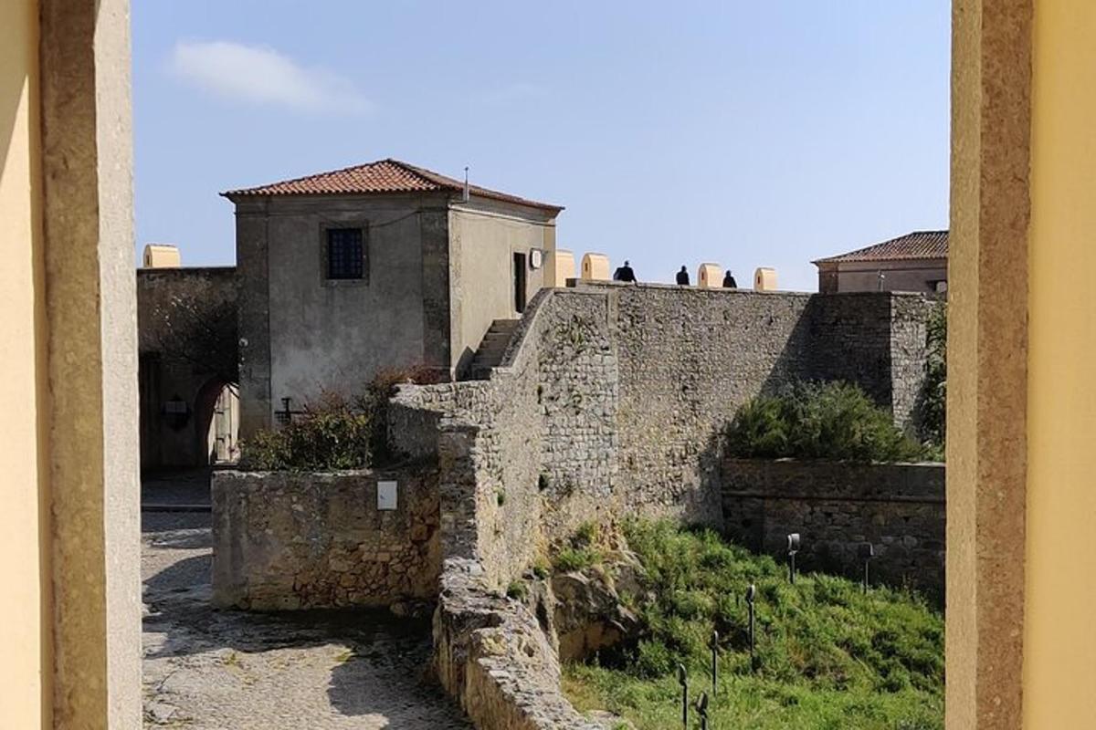 un antic mur de pedra amb un edifici al fons