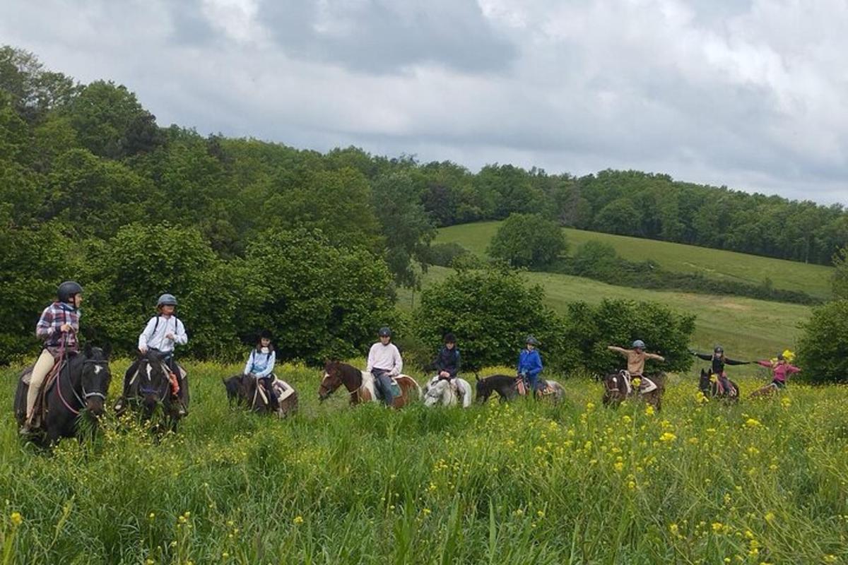 un grup de persones muntant a cavall en un camp