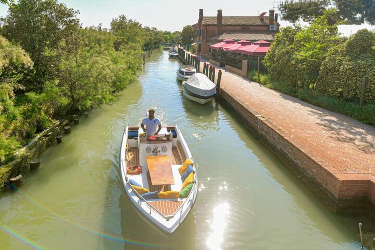 un bărbat pe o barcă într-un canal cu alte bărci