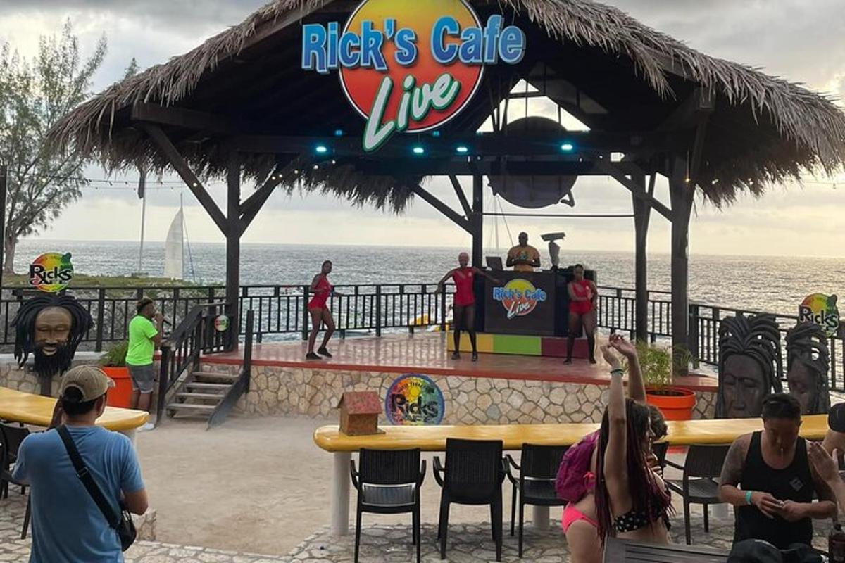 un gruppo di persone in piedi davanti a un palco sulla spiaggia