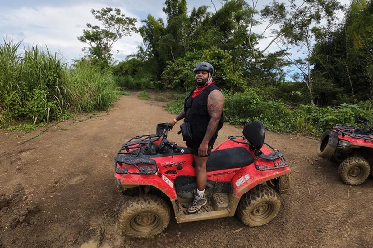 Egy férfi egy piros ATV-n ül egy földúton