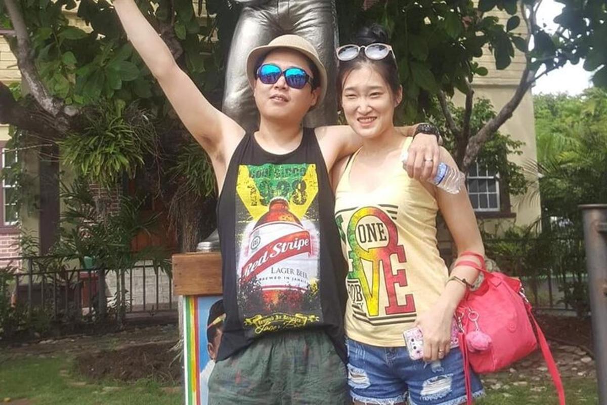 isang lalaki at isang babae na nakatayo sa harap ng isang estatwa