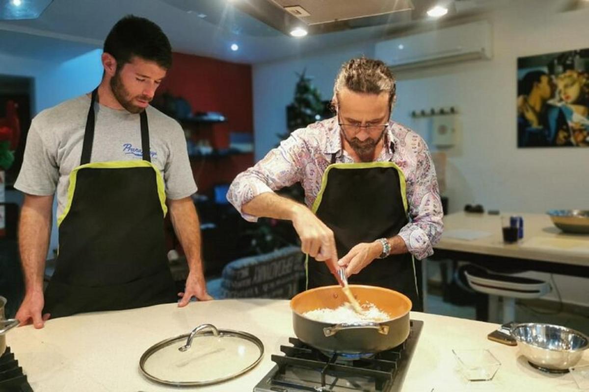 dva muži v kuchyni připravují jídlo na pánvi