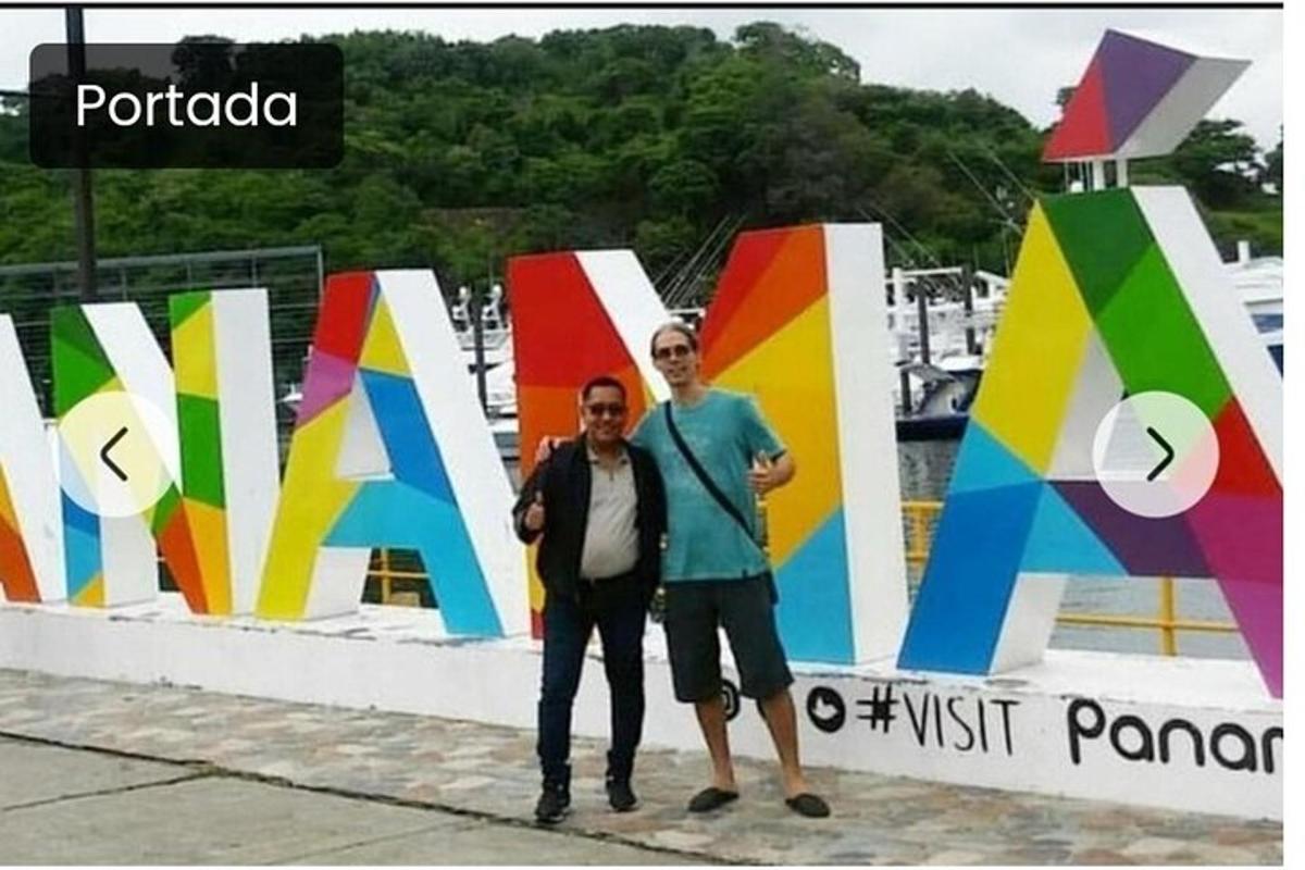 Δύο άνδρες στέκονται μπροστά σε μια πολύχρωμη πινακίδα