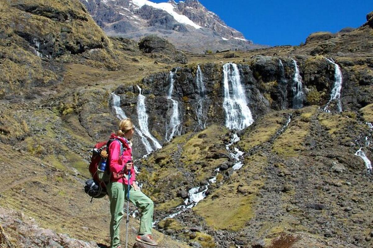 una donna in piedi su una montagna con una cascata