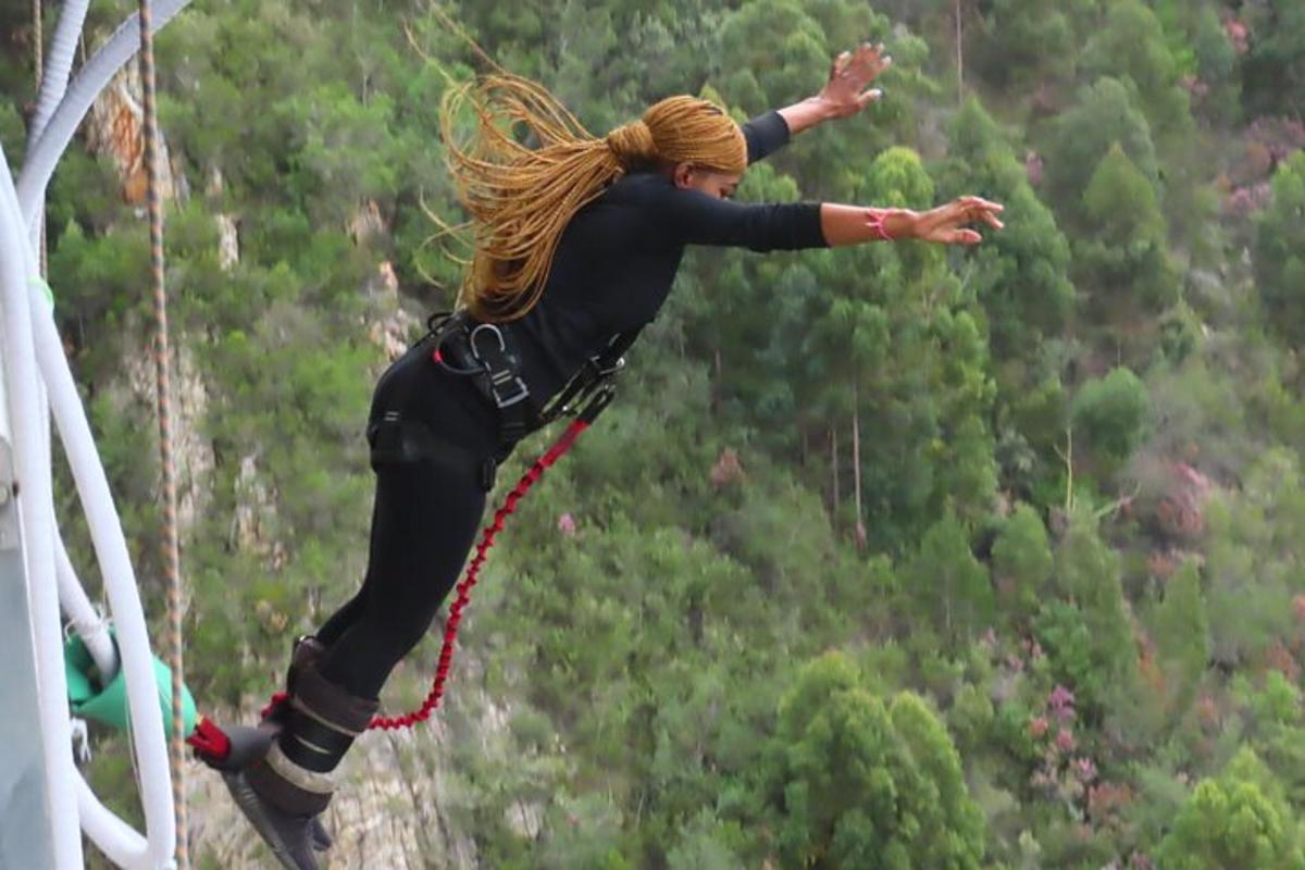 žena skákající do vzduchu na zip line