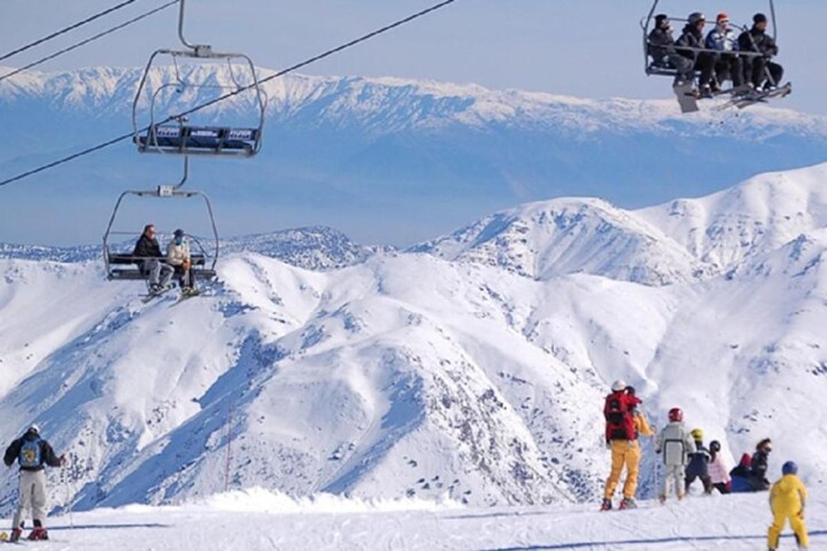 um grupo de pessoas andando de teleférico em uma montanha coberta de neve