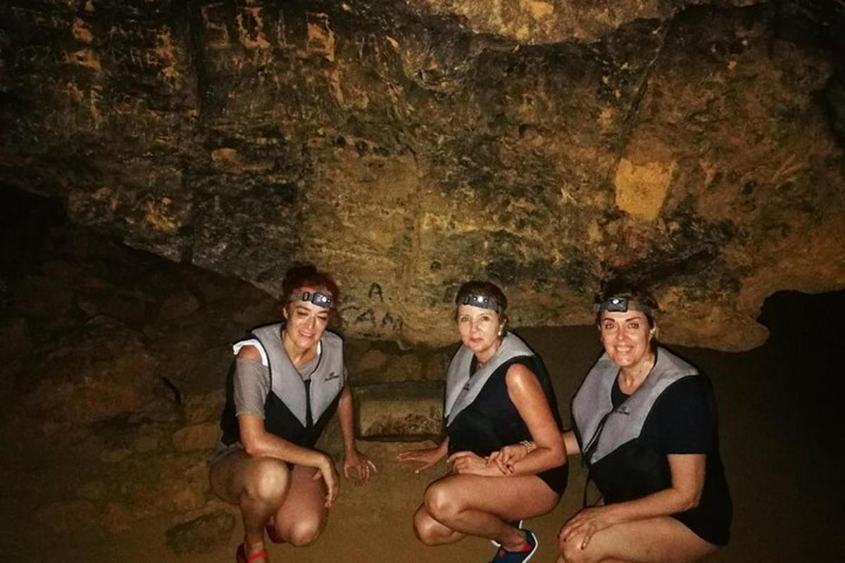 tiga orang wanita sedang duduk di hadapan sebuah gua