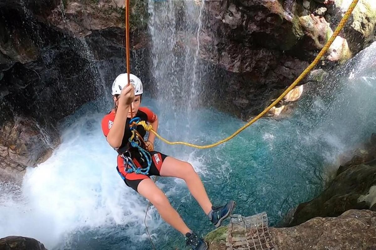 seorang wanita sedang rappelling dari air terjun