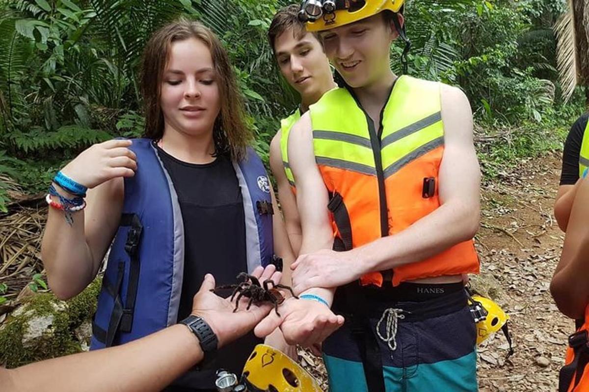 a group of people standing next to a woman holding a spider
