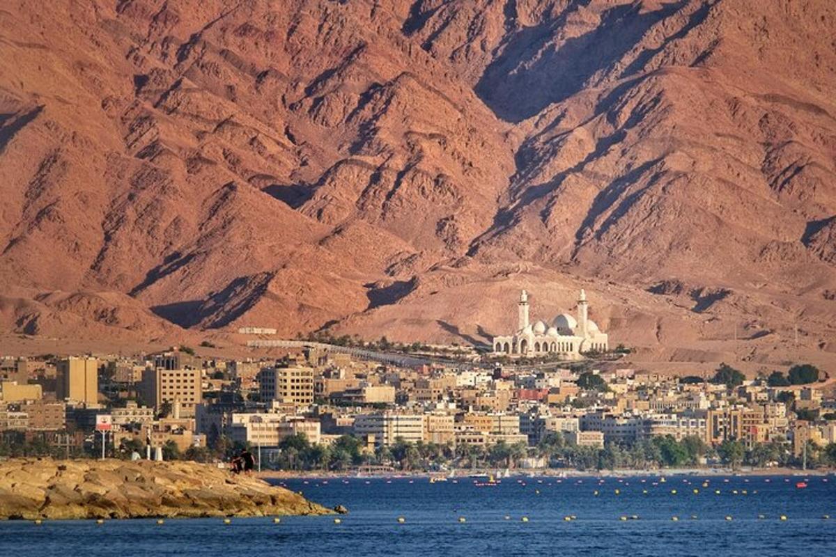 a city in the middle of the water with mountains