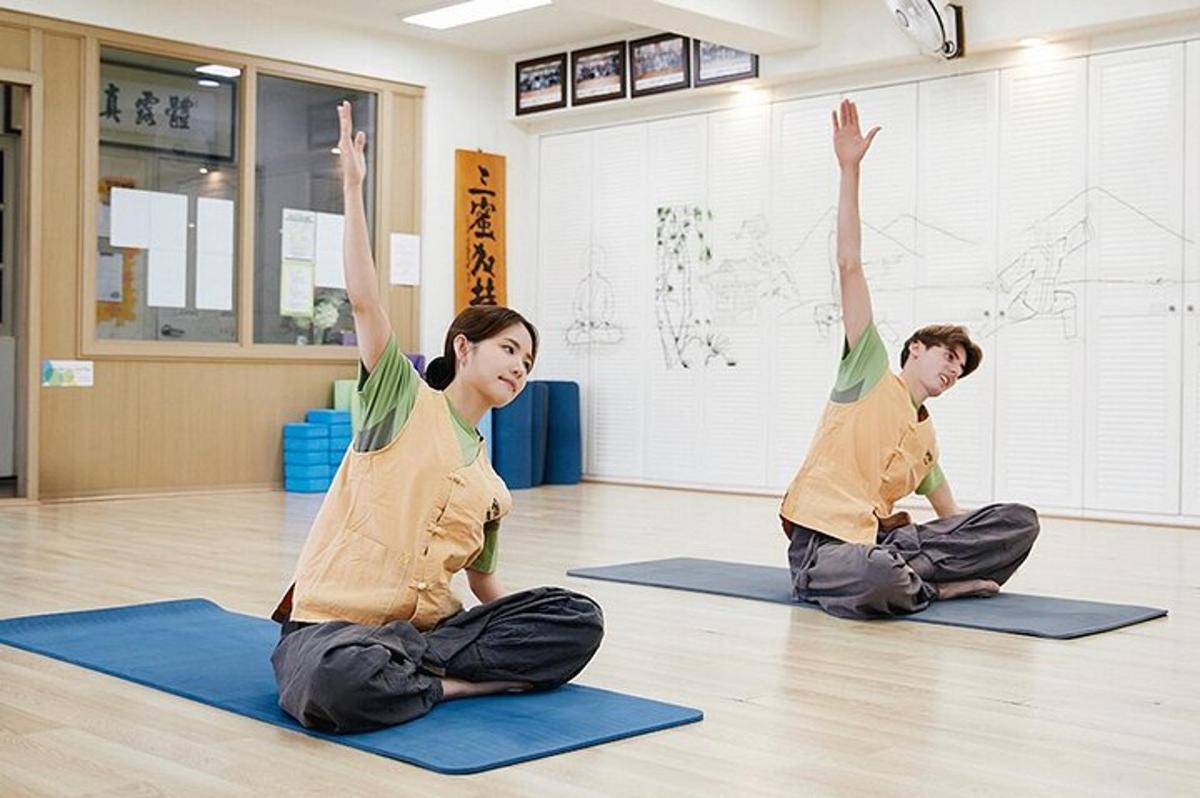 un uomo e una donna seduti sul pavimento che fanno yoga