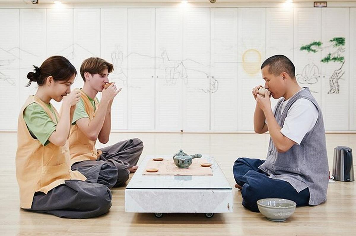três pessoas sentadas no chão comendo comida
