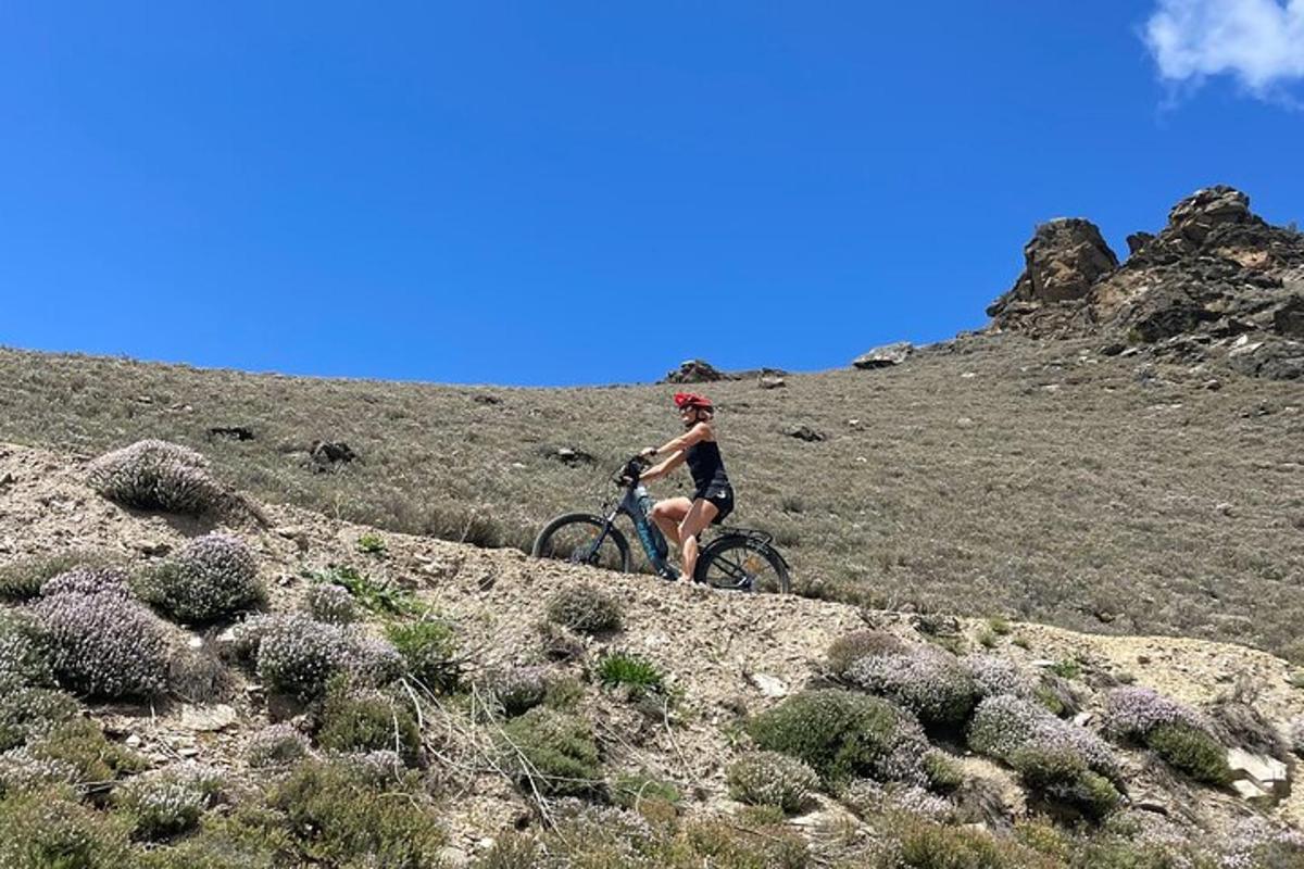 una persona anant en bicicleta per un turó