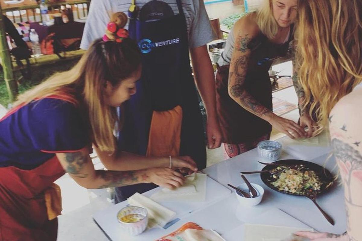 due donne in piedi attorno a un tavolo che preparano il cibo