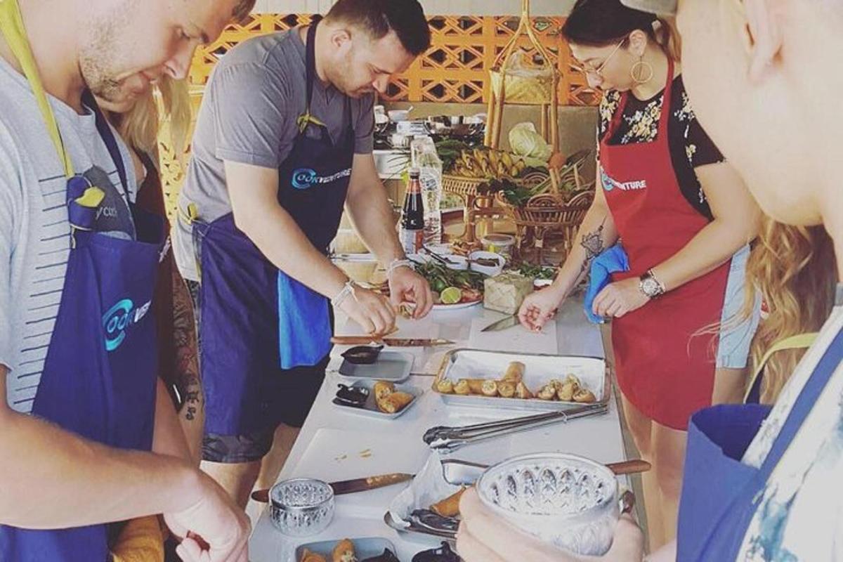 un gruppo di persone in piedi attorno a un tavolo con del cibo