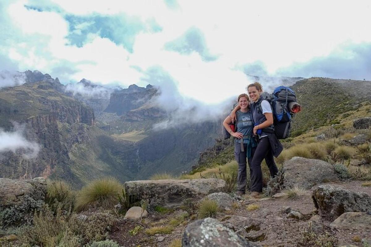 dua orang berdiri di atas gunung