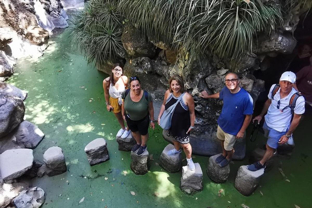 eine Gruppe von Menschen steht auf Felsen im Wasser
