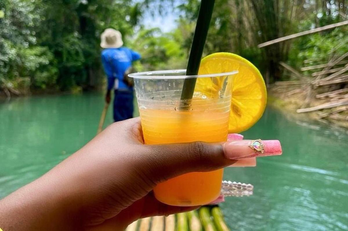 una mano che tiene un drink con una fetta d'arancia