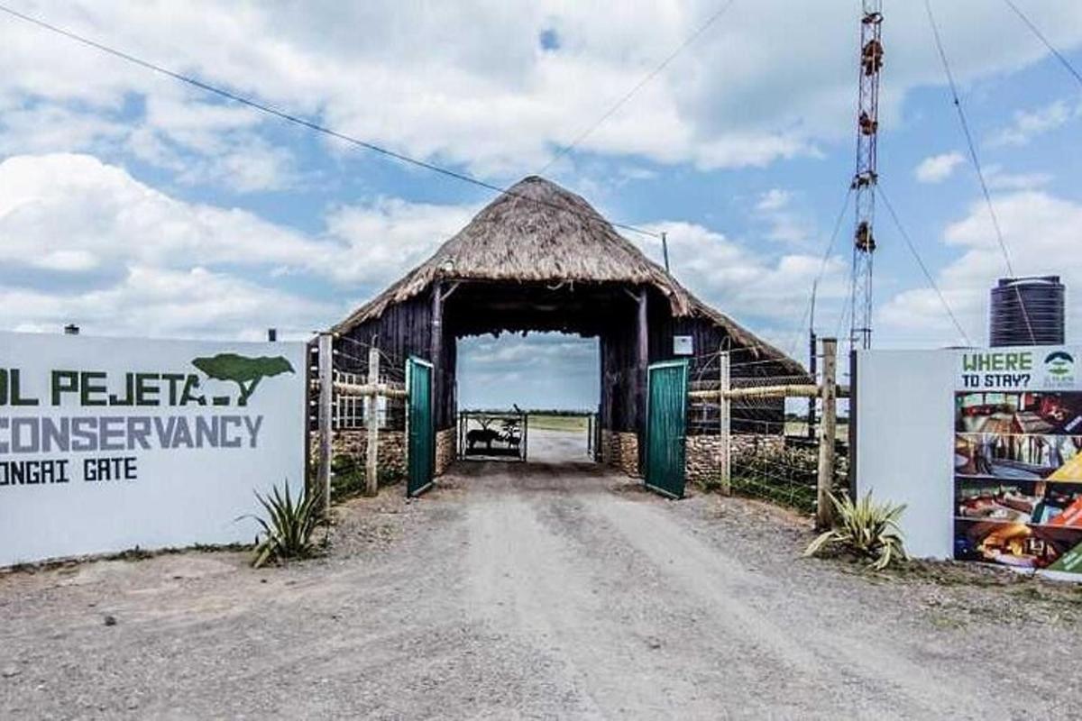 a barn with a door open on a dirt road