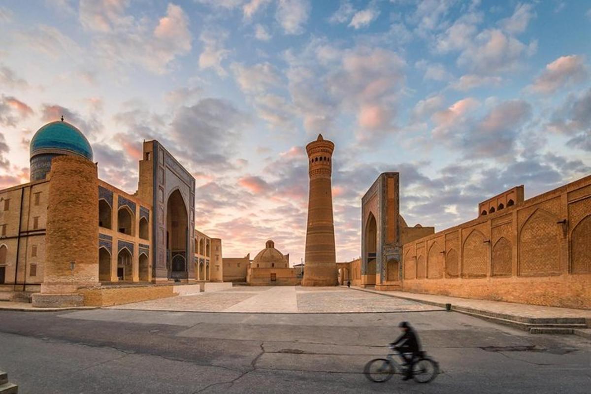 a person riding a bike in front of a mosque
