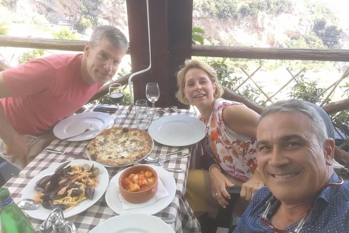 μια ομάδα ανθρώπων που κάθονται σε ένα τραπέζι με φαγητό