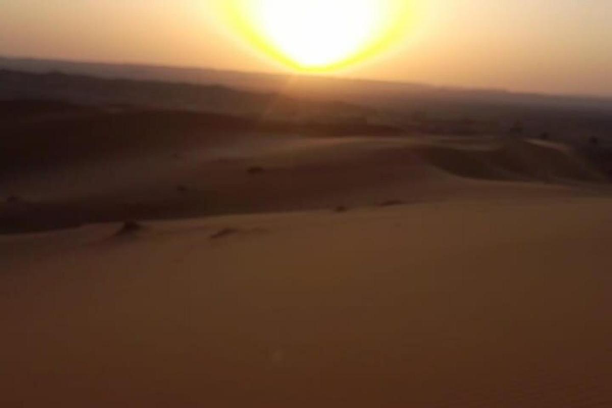 un tramonto nel deserto con il sole nel cielo