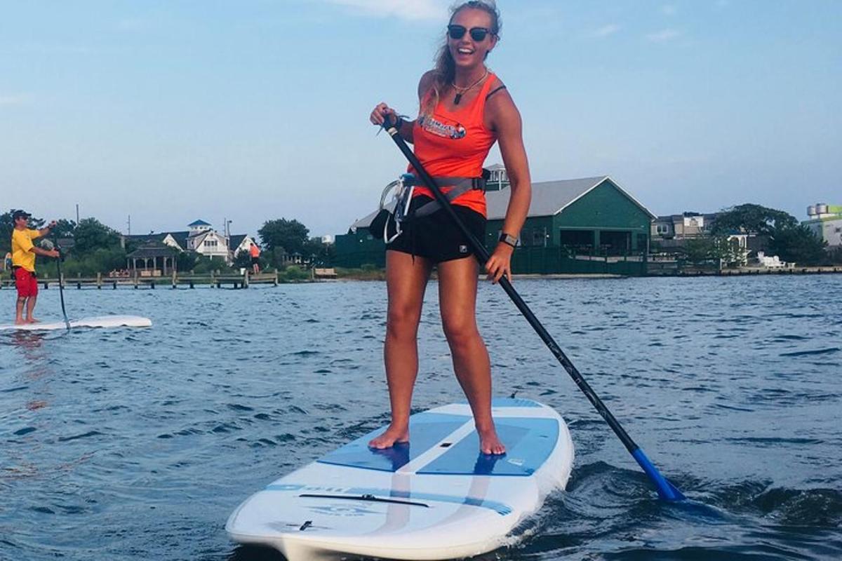 a woman is standing on a paddle board on the water