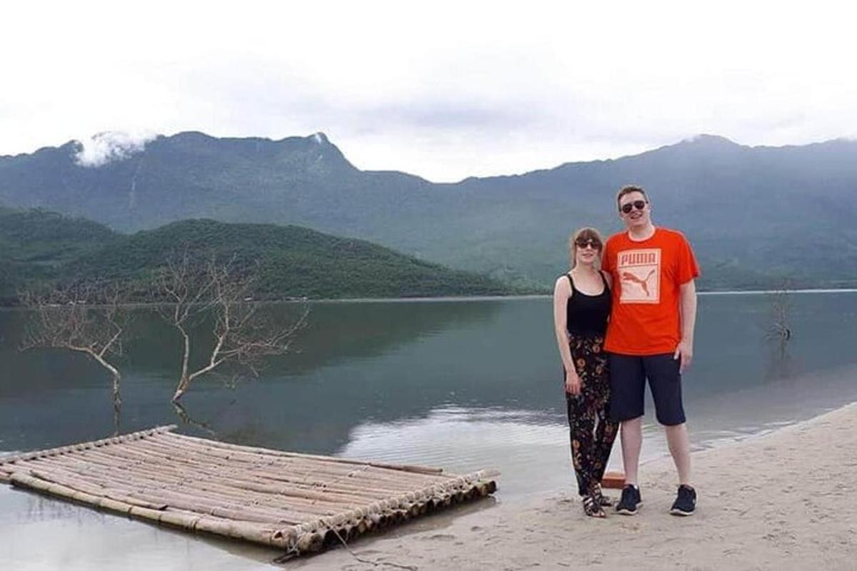 một người đàn ông và một người phụ nữ đứng trên bãi biển cạnh một hồ nước