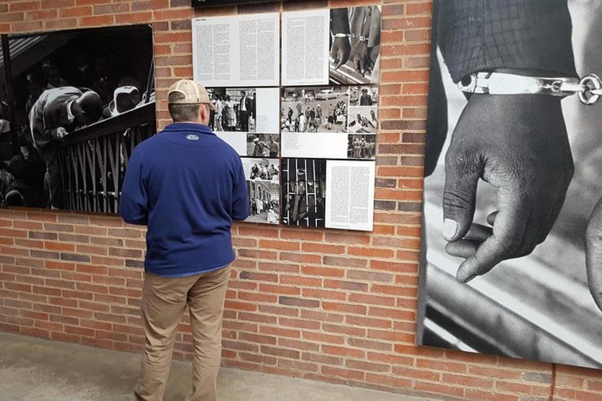 mees vaatab seina, millel on rusikaga plakat