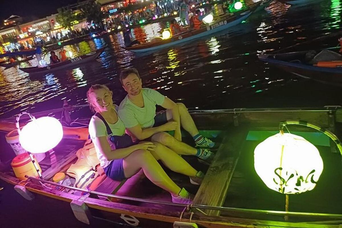 two people sitting on a boat in the water at night