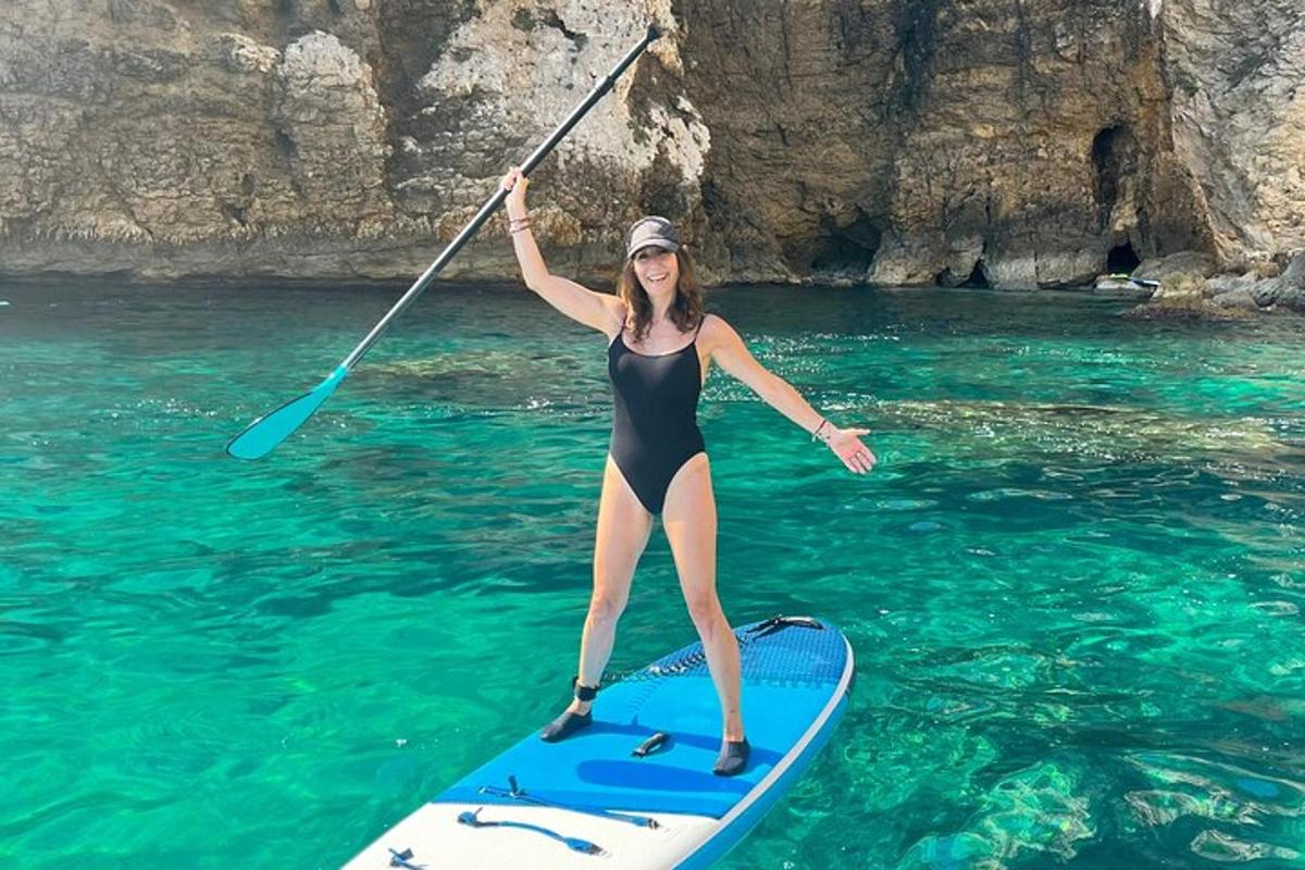 o femeie care ține o vâslă pe o placă de surf în apă