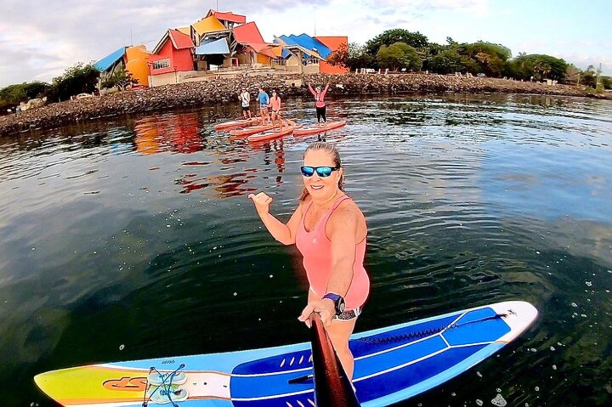 žena stojící na paddleboardu ve vodě