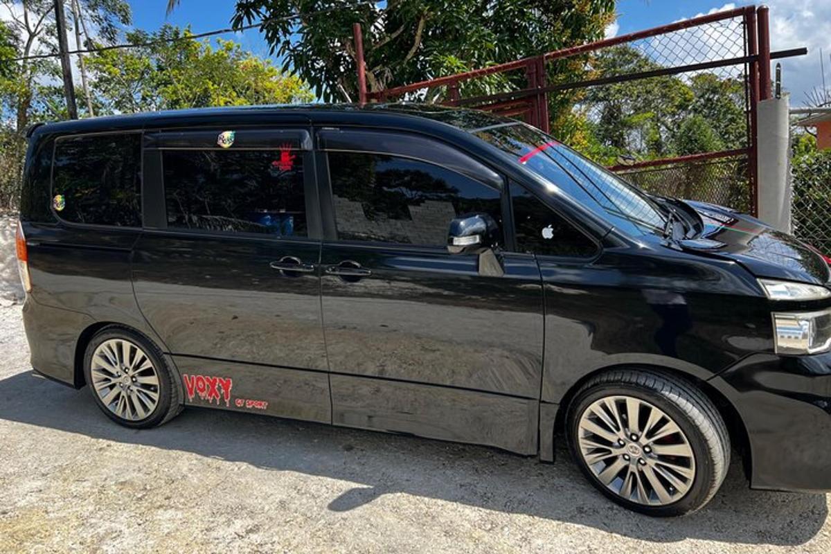 una petita furgoneta negra aparcada en un aparcament