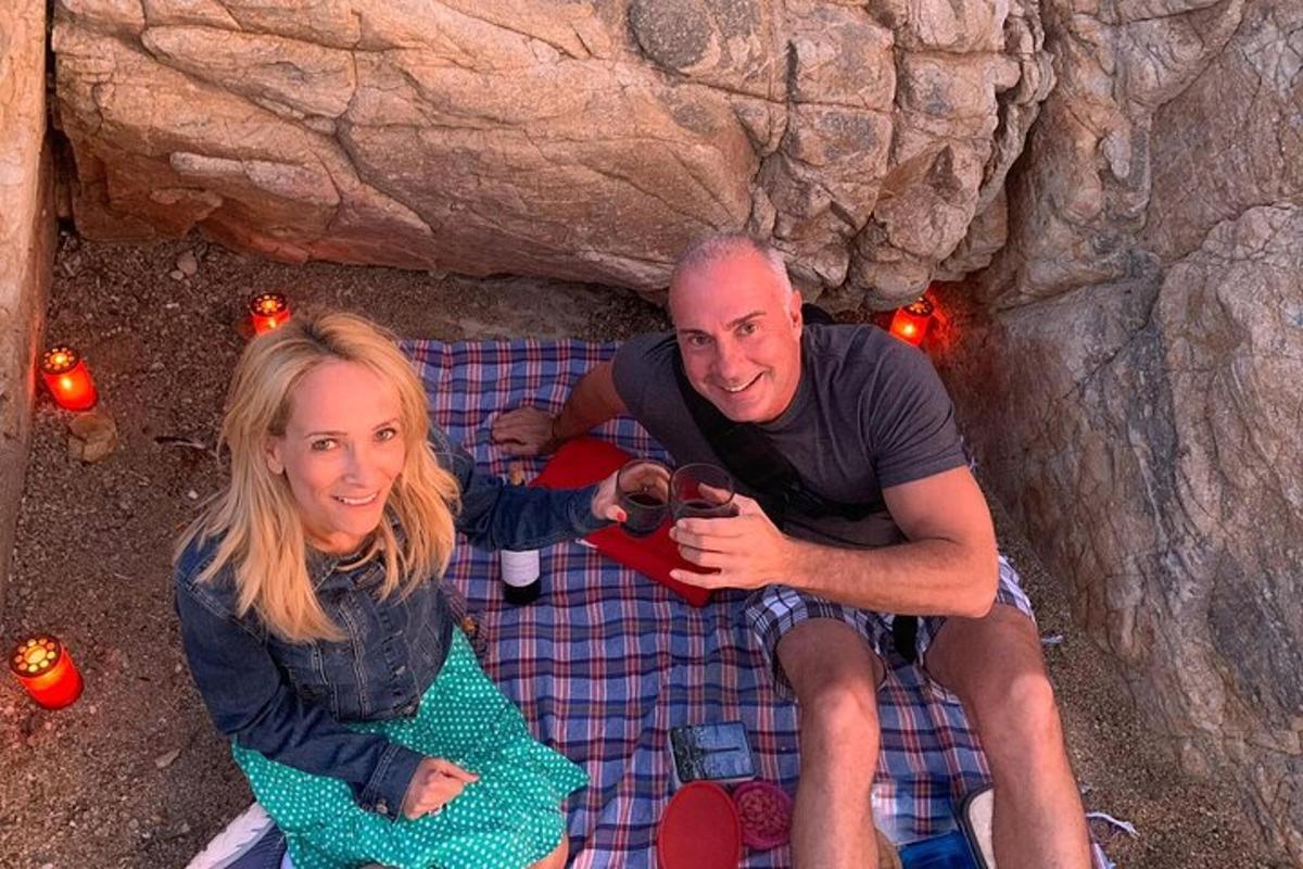 un uomo e una donna seduti su un letto in una grotta