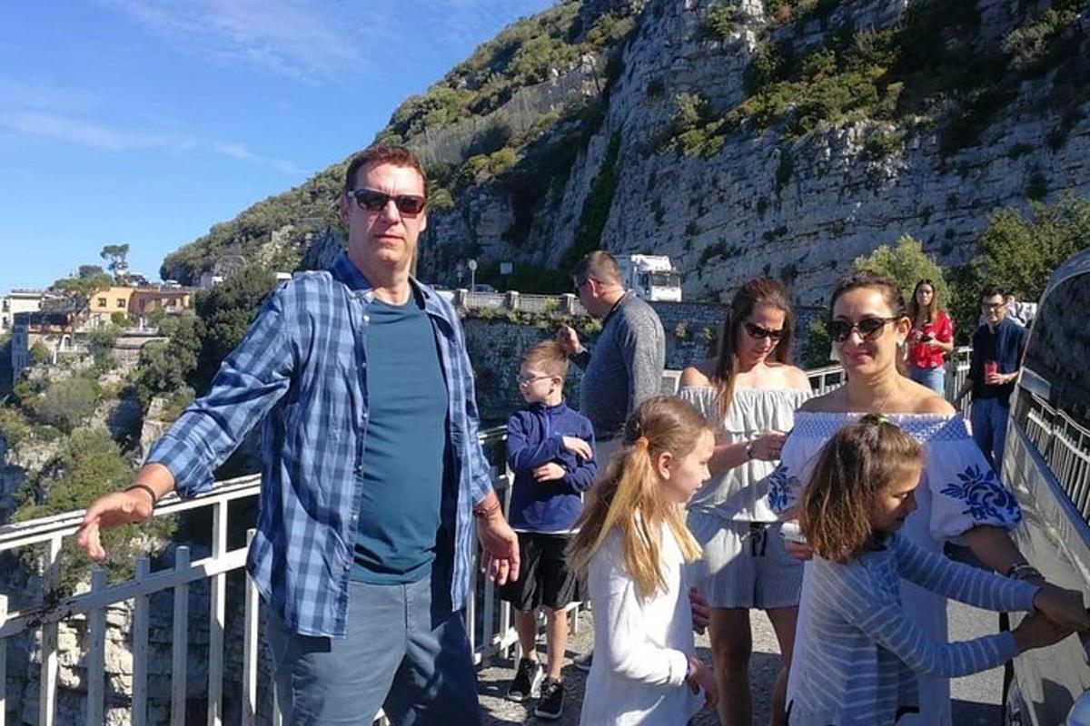 skupina lidí stojících na zábradlí s horou