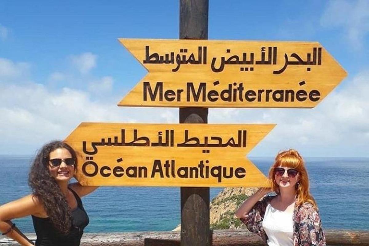 Δύο γυναίκες που στέκονται δίπλα σε μια πινακίδα δρόμου με πινακίδες
