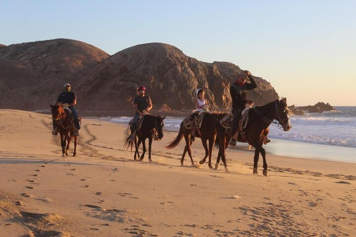 un gruppo di persone a cavallo sulla spiaggia
