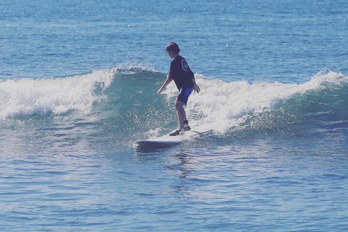 muž jedoucí na vlně na surfovém prkně v oceánu