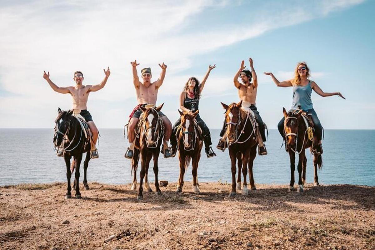 un gruppo di persone a cavallo sulla spiaggia